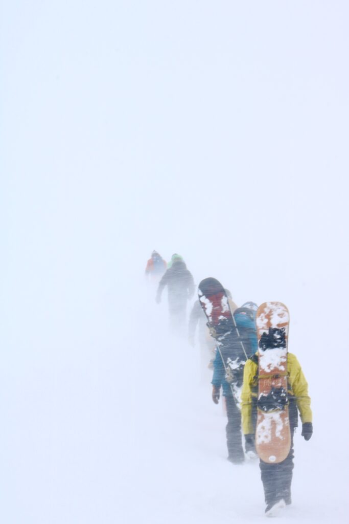 Riding the backcountry is a division of skiing that requires a nudge from a friend.  As this group of riders trek out into a whiteout didn't decide first to do this alone.  They were invited first.